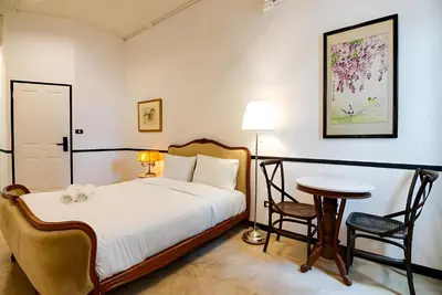 a bedroom with a bed and a table and chairs at XX The Character China Town - เดอะ คาแรคเตอร์ เยาวราช in Samphanthawong