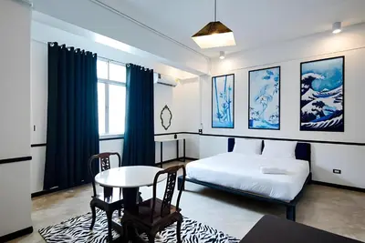 a bedroom with a bed and a table and a table and chairs at XX The Character China Town - เดอะ คาแรคเตอร์ เยาวราช in Samphanthawong