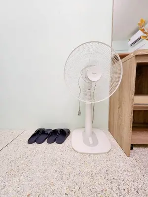 a white fan sitting on the floor next to a pair of shoes at 804-STP Homely room Free Wi-Fi and Near BTS line in Bangkok