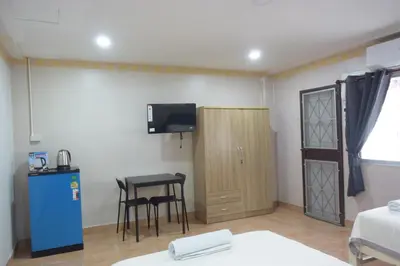a room with a table and a small table and a tv at Tawan Room#6 in Bangna