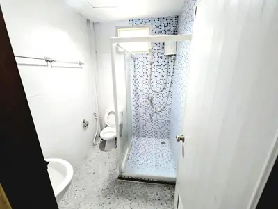 a white bathroom with a shower and a toilet at Asia Mahanakhorn Travel in Bangkok