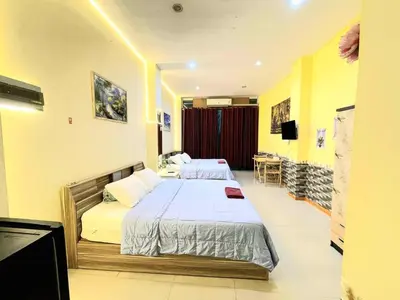 a hotel room with two beds and a television at Asia Mahanakhorn Travel in Bangkok