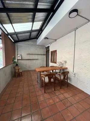 a patio with a wooden table and benches at Siam Breeze Inn - Self Check-in in Bangkok