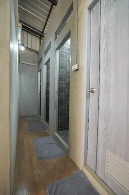 an empty hallway with a row of doors and mats at Siam Breeze Inn - Self Check-in in Bangkok