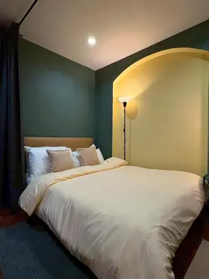 a bedroom with a large bed with white sheets at Hansa Heritage home in Khao San in Bangkok