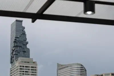 a view of a tall building from a window at Ease at Sathorn Hostel and Coworking Space in Bangkok