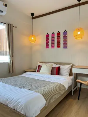 a bedroom with a large bed with colorful pillows at Ease at Sathorn Hostel and Coworking Space in Bangkok