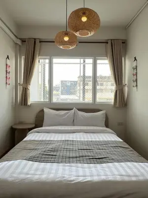 a bedroom with a large bed with a window at Ease at Sathorn Hostel and Coworking Space in Bangkok