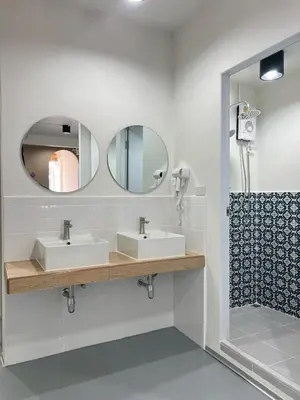a bathroom with two sinks and a mirror at Ease at Sathorn Hostel and Coworking Space in Bangkok