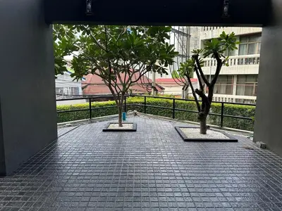 two trees on a tiled floor with a balcony at Condo, 3-min walk to BTS, Sky pool, Gym, Wifi, Self check-in at pickup point in Bangkok