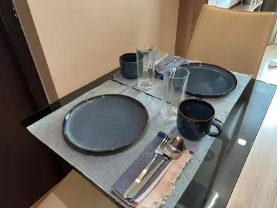 a table with two empty plates and utensils on it at Condo, 3-min walk to BTS, Sky pool, Gym, Wifi, Self check-in at pickup point in Bangkok