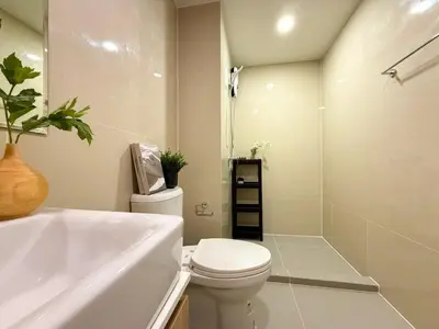 a white bathroom with a toilet and a sink at Serene Tropical 1BR - Ultra Fast Wifi - Sathorn in Bangkok