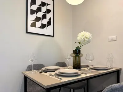 a dining room table with plates and wine glasses at Stylish Tropical l 2BR - Ultra Fast Wifi - Sathorn in Bangkok