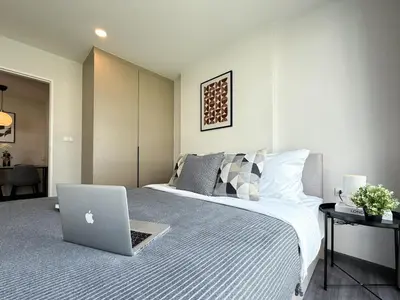 a bedroom with a bed with a laptop on it at Stylish Tropical l 2BR - Ultra Fast Wifi - Sathorn in Bangkok