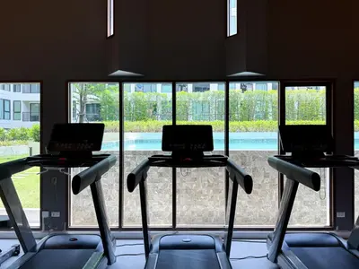 a gym with three elliptical machines with laptops on them at Stylish Tropical l 2BR - Ultra Fast Wifi - Sathorn in Bangkok