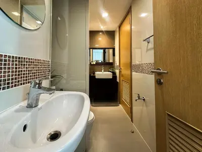 a bathroom with a sink and a toilet and a mirror at Contemporary Premier 1BR - Ultra Fast Wifi - BTS Nana in Bangkok