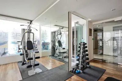 a gym with treadmills and ellipticals and mirrors at Contemporary Premier 1BR - Ultra Fast Wifi - BTS Nana in Bangkok