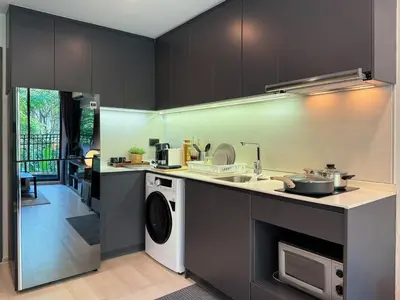 a kitchen with a sink and a washing machine at Contemporary Downtown - Ultra Fast WiFi - BTS Asoke in Bangkok
