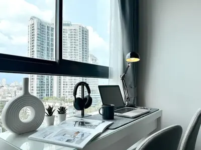 a desk with a laptop computer and a window at Refined High-Rise 1BR - Fast Wifi - BTS Phra Khanong in Bangkok