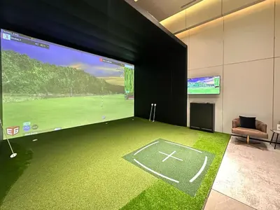 a room with a large screen with a golf game on it at Refined High-Rise 1BR - Fast Wifi - BTS Phra Khanong in Bangkok