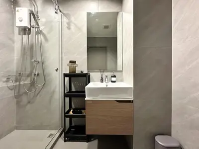 a bathroom with a sink and a shower with a mirror at Refined High-Rise 1BR - Fast Wifi - BTS Phra Khanong in Bangkok
