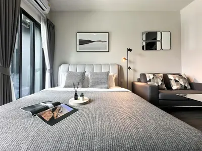 a bedroom with a large bed and a couch at Refined High-Rise 1BR - Fast Wifi - BTS Phra Khanong in Bangkok