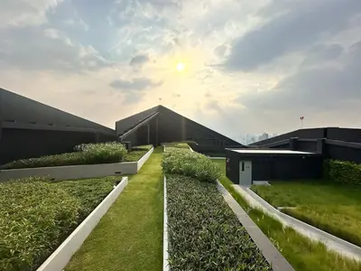 a view of the roofs of two buildings with plants at Refined High-Rise 1BR - Fast Wifi - BTS Phra Khanong in Bangkok