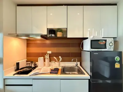 a small kitchen with a sink and a microwave at Transquil Modern 1BR - Ultra Fast WiFi - BTS Ari in Bangkok