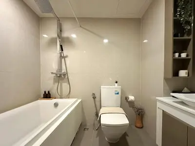 a bathroom with a toilet and a tub and a sink at Stylish Downtown 1BR - Ultra Fast WiFi - BTS ThongLor in Bangkok