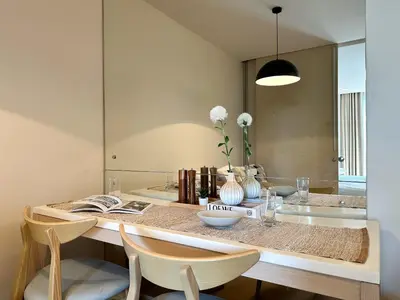 a dining room with a table and chairs and a mirror at Stylish Downtown 1BR - Ultra Fast WiFi - BTS ThongLor in Bangkok