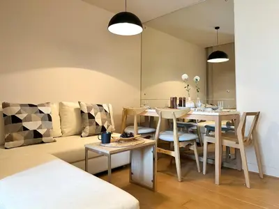 a living room with a table and a couch at Stylish Downtown 1BR - Ultra Fast WiFi - BTS ThongLor in Bangkok