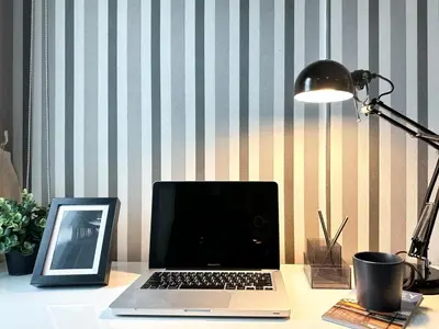 a laptop computer sitting on a desk next to a lamp at Tropical Modern 1BR - Ultra Fast Wifi - Thong Lo in Bangkok