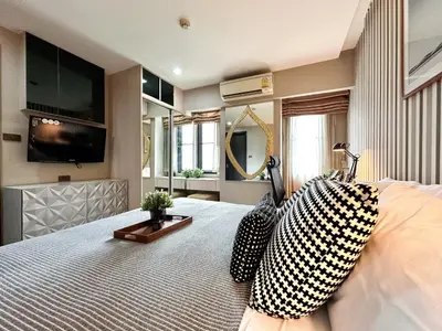a bedroom with a bed with a tv on the wall at Tropical Modern 1BR - Ultra Fast Wifi - Thong Lo in Bangkok