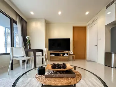 a living room with a table and a tv at Spacious High Rise 2BR - Ultra Fast Wifi - Phrom Phong in Bangkok