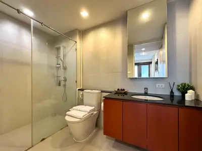 a bathroom with a toilet and a sink and a mirror at Spacious High Rise 2BR - Ultra Fast Wifi - Phrom Phong in Bangkok