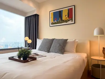 a bedroom with a white bed and a large window at Spacious High Rise 2BR - Ultra Fast Wifi - Phrom Phong in Bangkok