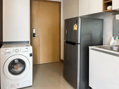 a kitchen with a washing machine and a refrigerator at Expansive Premier 1BR - Ultra Fast Wifi - Phrom Phong in Bangkok
