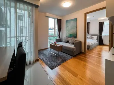 a living room with a couch and a large window at Expansive Premier 1BR - Ultra Fast Wifi - Phrom Phong in Bangkok
