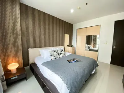 a bedroom with a bed with a book on it at Upscale Modern 2BR - Ultra Fast WiFi - BTS Asoke in Bangkok