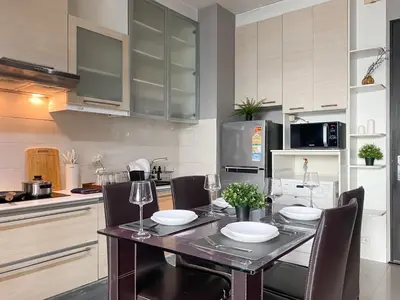 a kitchen with a dining table with chairs and a kitchen with at Upscale Modern 2BR - Ultra Fast WiFi - BTS Asoke in Bangkok