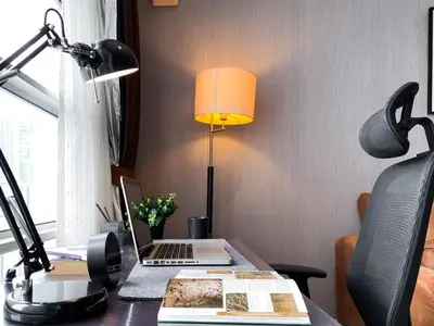 a desk with a laptop and a lamp on it at Upscale Modern 2BR - Ultra Fast WiFi - BTS Asoke in Bangkok