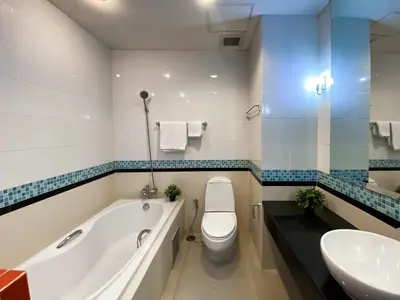 a bathroom with a tub and a toilet and a sink at Upscale Modern 2BR - Ultra Fast WiFi - BTS Asoke in Bangkok