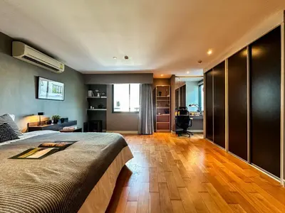 a bedroom with a large bed and a living room at Stylish Exquisite 1BR in Bangkok