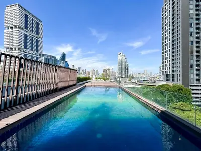 a large pool of water in a city with tall buildings at Stylish Exquisite 1BR in Bangkok