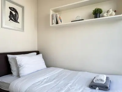 a bedroom with a bed and a shelf at Ruamrudee Modern - Ultra Fast WiFi - BTS Ploenchit in Bangkok