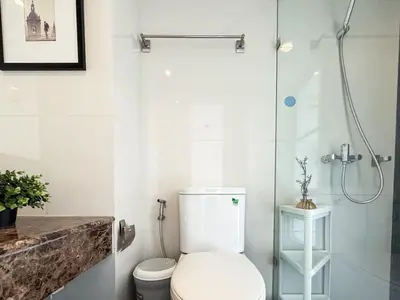 a white bathroom with a toilet and a shower at Ruamrudee Modern - Ultra Fast WiFi - BTS Ploenchit in Bangkok