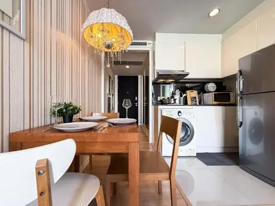 a kitchen and dining room with a wooden table at Ruamrudee Modern - Ultra Fast WiFi - BTS Ploenchit in Bangkok