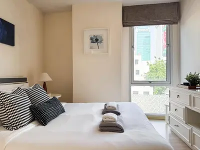 a bedroom with a large white bed with towels on it at Ruamrudee Modern - Ultra Fast WiFi - BTS Ploenchit in Bangkok