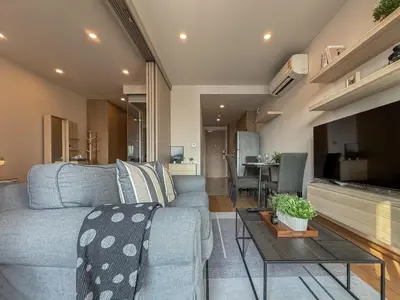 a living room with a couch and a table at Upscale Skyview 1BR - Ultra Fast Wifi - Chitlom in Bangkok