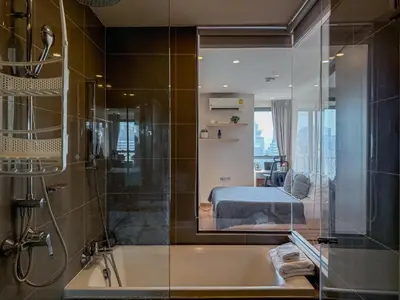 a bathroom with a bath tub and a bedroom at Upscale Skyview 1BR - Ultra Fast Wifi - Chitlom in Bangkok